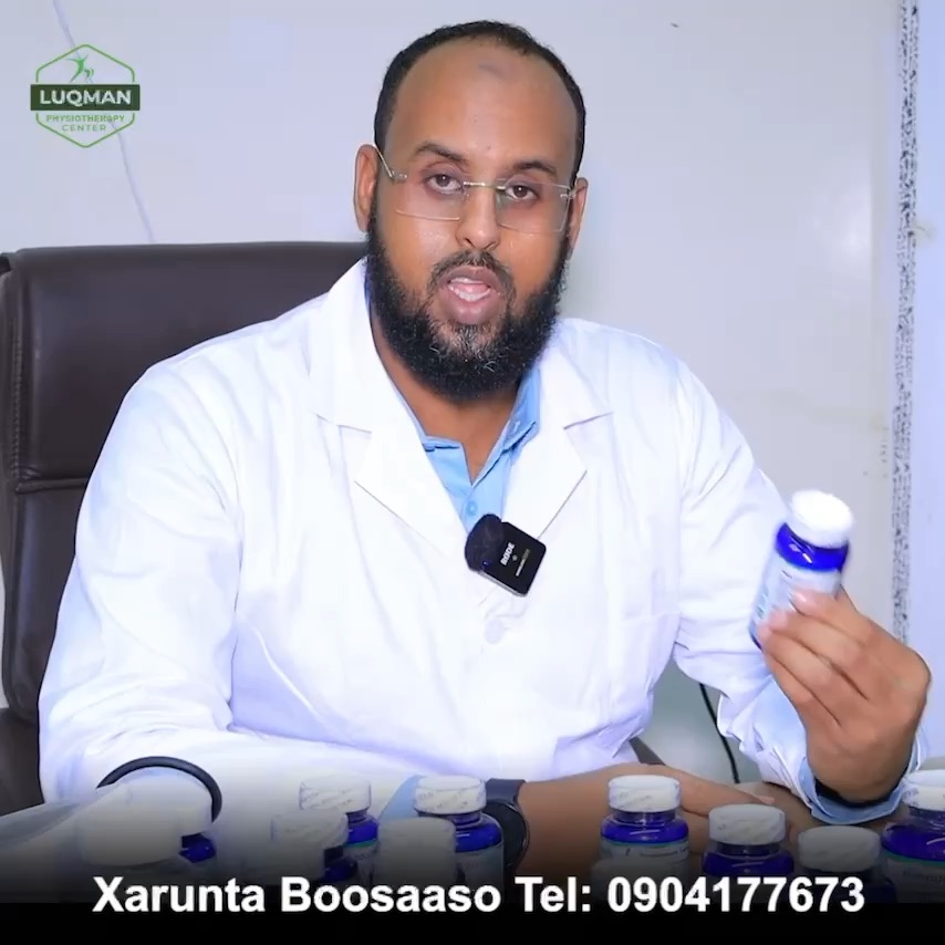 A clinician in a white coat holding a bottle from the herbal range