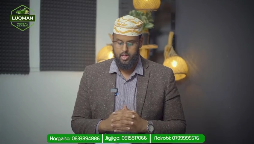 A man in a jacket and koofiyad speaking to camera