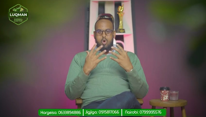 A man in a green jumper speaking to camera