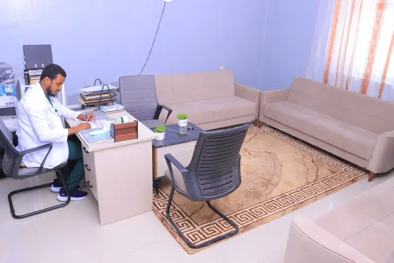 Consultation room with a desk and seating for family