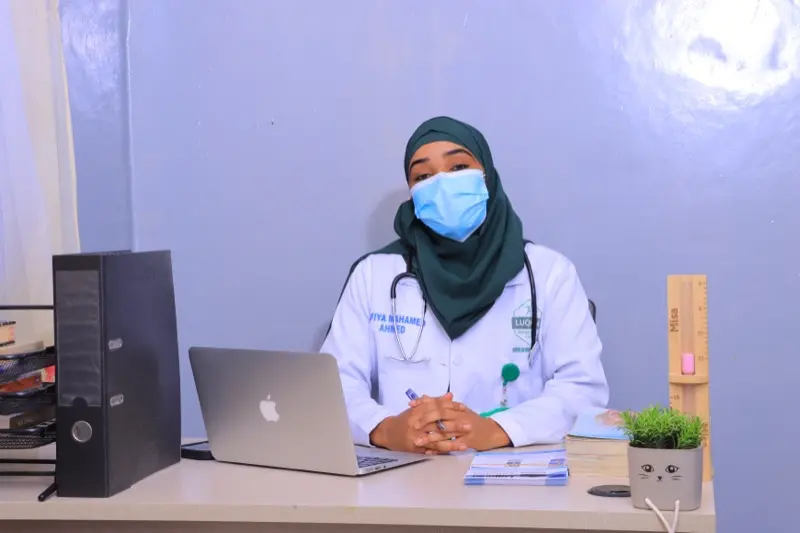 Safiya Mahamed Ahmed at her desk with a stethoscope